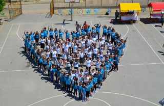 A group of Mary's Meals supporters stand together to form a giant heart.