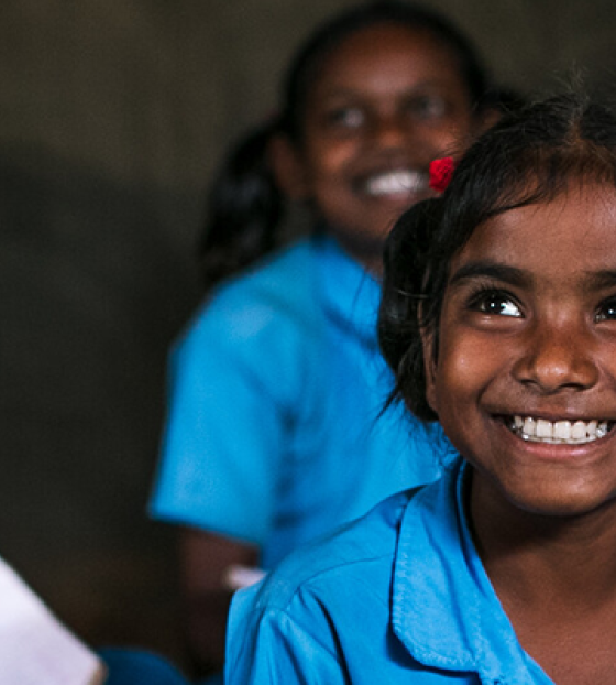 Children sitting and smilling in class.
