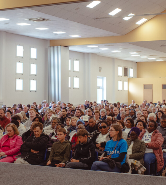 Image of a priest and Mary's Meals volunteer giving a talk at a parish.