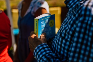 Someone holding a copy of "The Shed That Fed 2 Million Children"