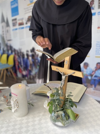 priest gives blessing, cross on the table